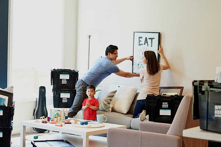 family hanging picture in new home