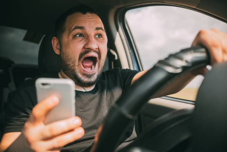 driver looking at phone and screaming