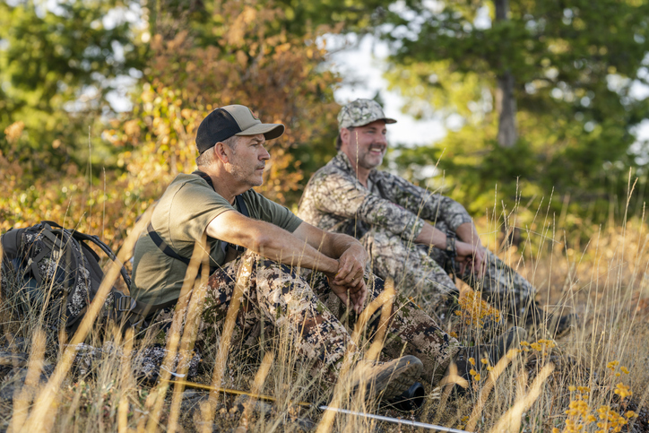 two hunters sitting in a field