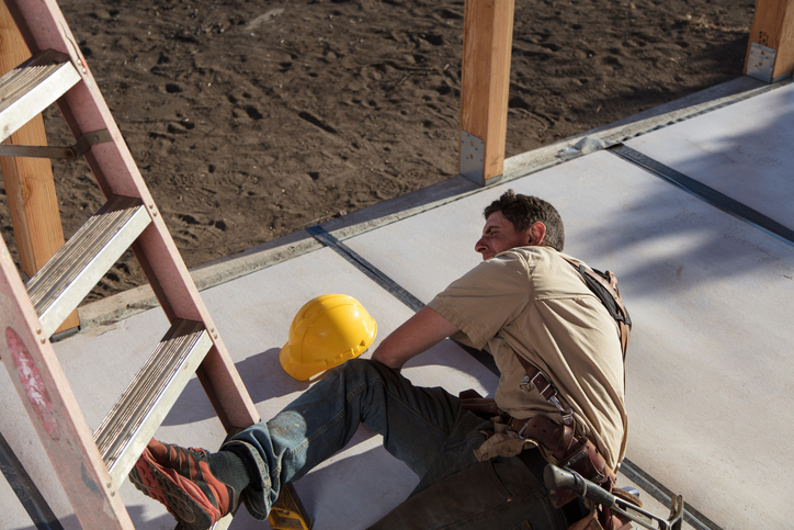 Carpenter building a home at construction site. Falling off ladder.