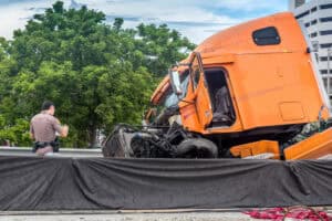 an officer investigates a truck crash scene